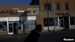 Seorang remaja putra mengendarai sepeda melintas di supermarket Al-Noor dan toko Hookah di Hamtramck, Michigan, 14 November 2016. (Foto: Reuters)