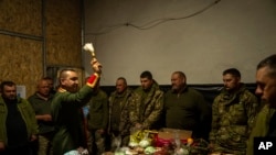 FILE—Priest Ivan blesses Ukrainian servicemen of the 72nd Separate Mechanized Brigade, during a Christian Orthodox Easter religious service, in Dnipropetrovsk region, Ukraine, early Sunday, May 5, 2024.