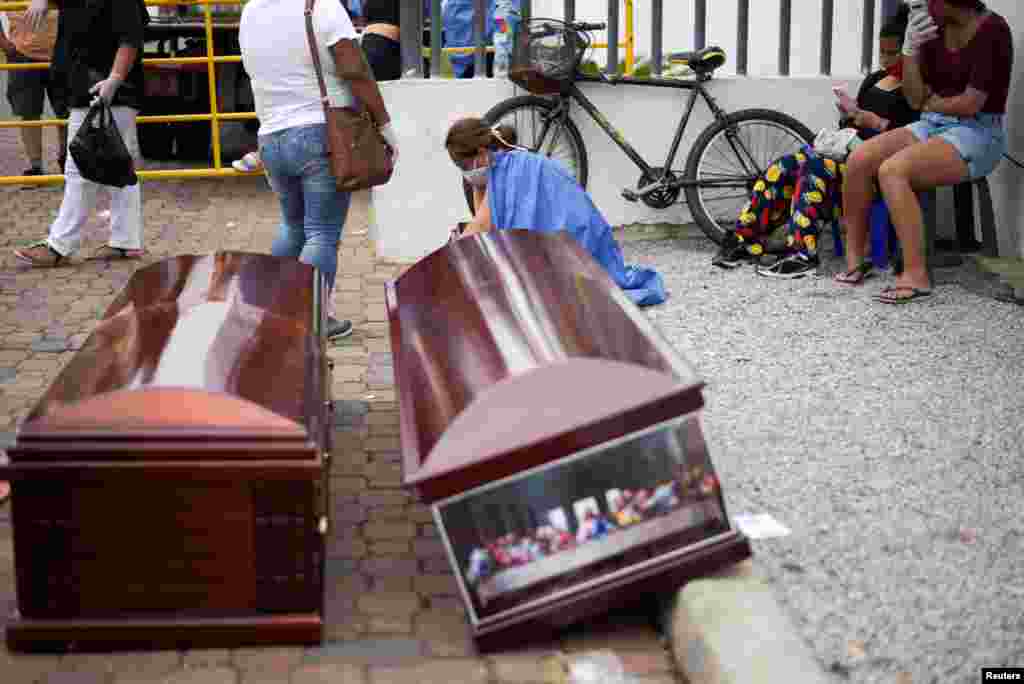 La gente espera junto a los ataúdes fuera del Hospital General Guasmo Sur, en Guayaquil, Ecuador, 1 de abril de 2020.