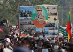 FILE - Military supporters carry a portrait of junta leader General Min Aung Hlaing as they celebrate the coup in Naypyitaw.