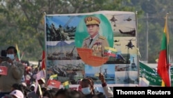Military supporters carry a portrait of junta leader General Min Aung Hlaing as they celebrate the coup in Naypyitaw, Feb. 4, 2021.