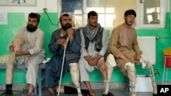 FILE —Afghan men who have lost their legs due to landmines wait to have their prosthetics checked at the International Committee of the Red Cross physical rehabilitation center in Kabul, Afghanistan, May 16, 2022.