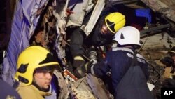 In this photo made available by the Oman Police, Omani civil defense workers rescue people from a damaged bus after a crash, near Nahdah area on the road connecting the cities of Fahud and Ibriin, in Oman, March 1, 2016.