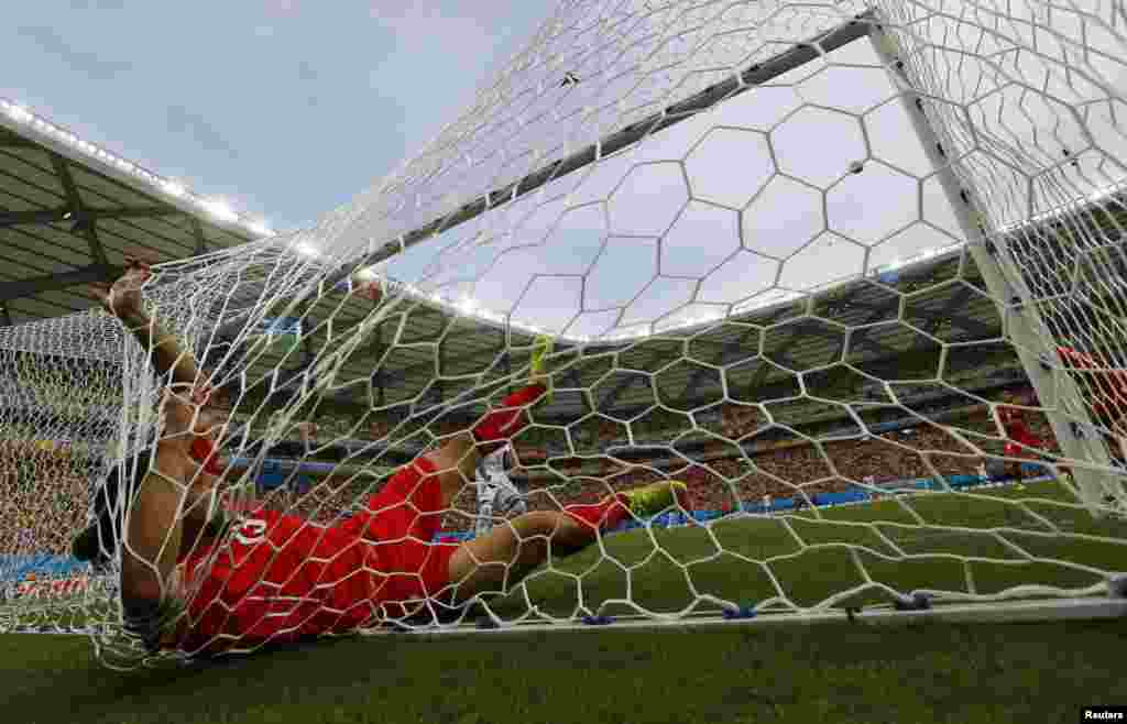 سوئٹزرلینڈ کے ریکارڈو روڈیگویز گول بچاتے ہوئے گول میں گرے ہوئے ہیں