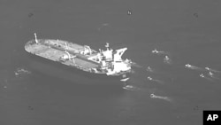 This still image from video released by the U.S. Navy shows the Panama-flagged oil tanker Niovi surrounded by Iranian Revolutionary Guard vessels in the Strait of Hormuz Wednesday, May 3, 2023. 