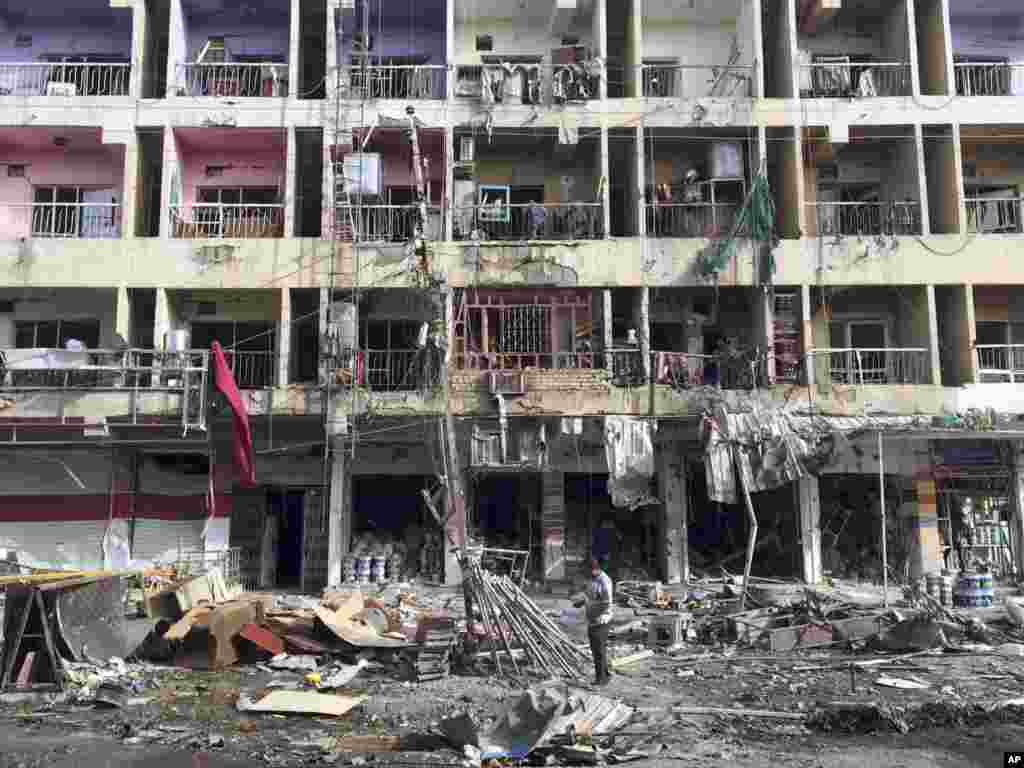 Iraqi civilians inspect the aftermath of a car bombing in the southeastern district of New Baghdad, Iraq, June 8, 2014. 