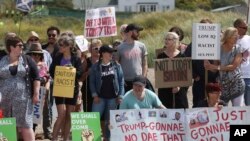 Manifestantes protestan en Escocia contra la visita del presidente de EE.UU., Donald Trump. Están en un playa cercana al Club de Golf Turnberry, propiedad del líder estadounidense. Julio 14 de 2018. Un activista en parapente que voló con un letrero cerca del campo de golf fue arrestado, informó la policía escocesa.