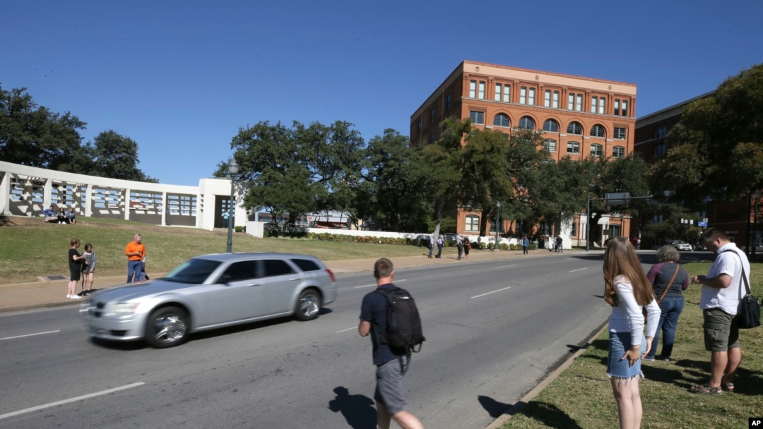 Tourists gather on the street where President John F. Kennedy's was shot from 6th floor of the book depository at Dealey Plaza in downtown Dallas, Oct. 25, 2017. 