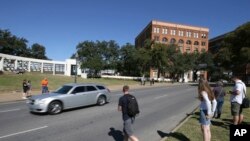 Tourists gather on the street where President John F. Kennedy's was shot from 6th floor of the book depository at Dealey Plaza in downtown Dallas, Oct. 25, 2017. 