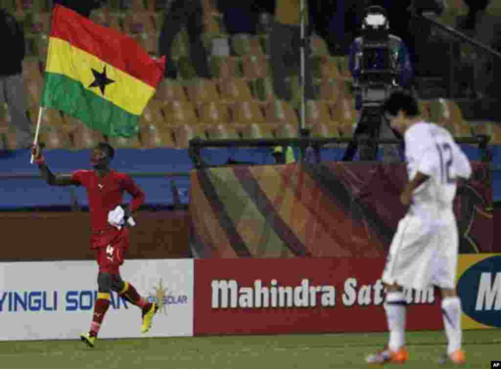 Ghana's John Pantsil, left, celebrates with the Ghanian flag as United States' Jonathan Bornstein, right, walks past during the World Cup round of 16 soccer match between the United States and Ghana at Royal Bafokeng Stadium in Rustenburg, South Africa, 