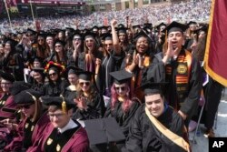 FILE - Graduating Boston College students cheer during commencement ceremonies, Monday, May 22, 2023, in Boston. (AP Photo/Steven Senne)