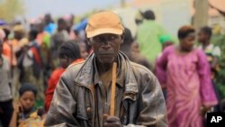 Nguli Nzafi who lost his wife and three children following attacks by assailants, stands with others at a camp for displace people in Bunia, Eastern Congo, Feb. 17, 2018.