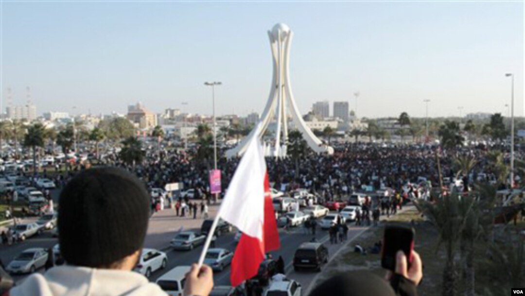 Warga Bahrain mengibarkan bendera dan mengambil foto para demonstran di ibukota, Manama, Selasa (2/15).