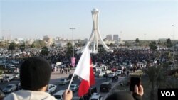 Warga Bahrain mengibarkan bendera dan mengambil foto para demonstran di ibukota, Manama, Selasa (2/15).