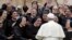 FILE - Pope Francis meets a group of Franciscan nuns during his weekly general audience, in St. Peter's Square, at the Vatican, Wednesday, May 9, 2018. 