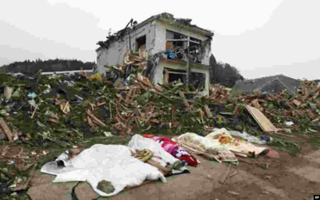 The bodies of victims are covered by blankets at a village destroyed by the earthquake and tsunami in Rikuzentakata in Iwate prefecture, northeast Japan March 15, 2011. REUTERS/Lee Jae-Won (JAPAN - Tags: DISASTER ENVIRONMENT)