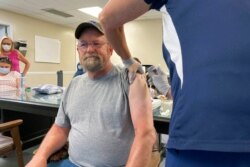 FILE - John Rogers receives a second dose of the COVID-19 vaccine in Taylorsville, Ky., June 17, 2021.