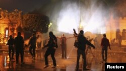 Protesters throw stones at security forces inside the presidential palace during clashes in front of the palace in Cairo, Egypt, February 1, 2013.