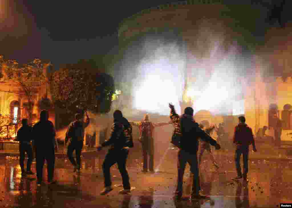 Protesters throw stones at security forces inside the presidential palace during clashes in front of the palace in Cairo, Feb. 1, 2013.