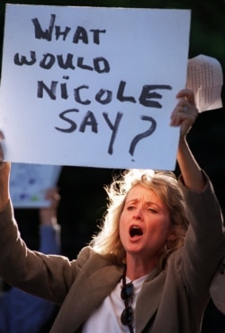 Protester Laurette Spang-McCook shouts at attendees of a fundraiser for the victims of domestic violence at the O.J. Simpson estate in Los Angeles, June 27, 1996.