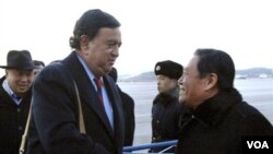 Bill Richardson (kiri) disambut oleh pejabat Kementerian Luar Negeri Korut, Li Gun di bandara Pyongyang, Korea Utara, Minggu, 19 Desember.