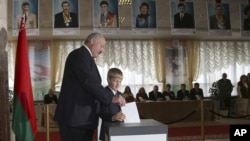 Belarusian President Alexander Lukashenko with his youngest son Nikolai casts his ballot at a polling station during parliamentary elections in Minsk, Belarus, Sunday, Sept. 23, 2012.