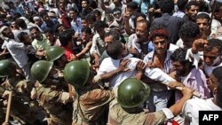 Binh sĩ Yemen đẩy người biểu tình chống chính phủ trong một cuộc biểu tình tại Taiz đòi Tổng thống Ali Abdullah Saleh từ chức, ngày 9 tháng 4, 2011