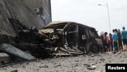 People gather at the site of a car bomb attack that killed the governor of Yemen's southern port city of Aden, Dec. 6, 2015. 