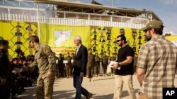 U.S. envoy William Roebuck, center, leaves the podium after speaking at a ceremony to celebrate U.S.-backed Syrian Democratic Forces defeat of Islamic State militants in Baghouz, at al-Omar Oil Field base, Syria, March 23, 2019