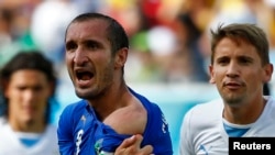 Giorgio Chiellini accusant Luis Suarez d'Uruguay d'avoir mordu son épaule, Coupe du monde 2014, le 24 juin 2014. (REUTERS/Tony Gentile )