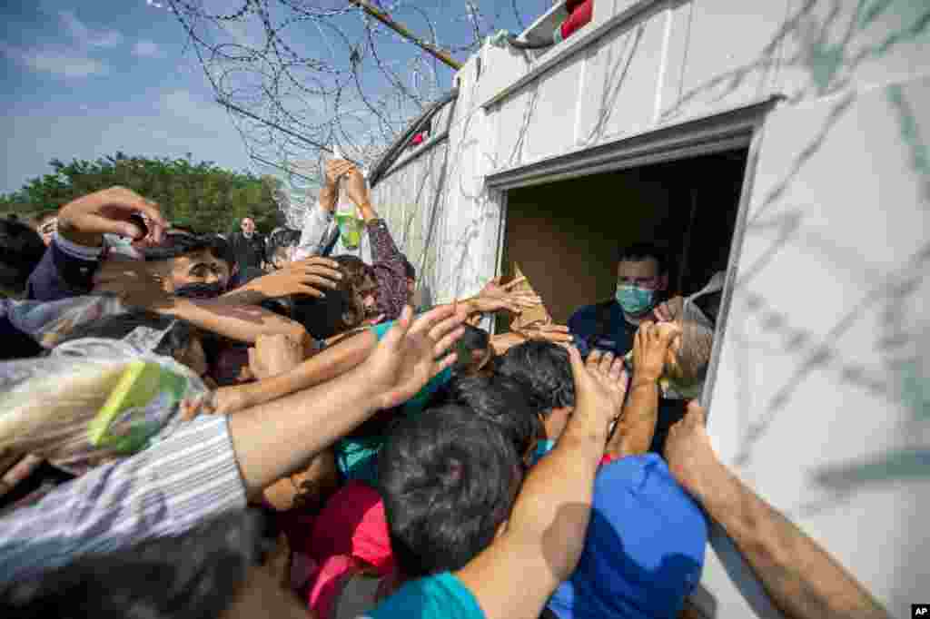 Police officers distribute food to migrants at the border to Hungary in Horgos, Serbia.