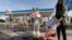 Members of People for the Ethical Treatment of Animals hold a demonstration with fake blood outside an ExxonMobil gas station to protest the oil company's support of the Iditarod Trail Sled Dog Race, Jan. 7, 2021, in Los Angeles. 