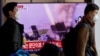 Men walk past a TV broadcasting a news report on North Korea firing a ballistic missile off its east coast, in Seoul, South Korea, Nov. 3, 2022. 