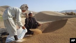 A woman writes on a poster demanding death by hanging for the four men convicted in the fatal gang rape of a young woman on a New Delhi bus last year, outside a court in New Delhi, Sept. 11, 2013. 