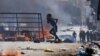 A boy runs past barricades as Senegalese demonstrators clash with riot police during a protest against the postponement of the February 25 presidential election, in Dakar, Senegal, February 4, 2024. 