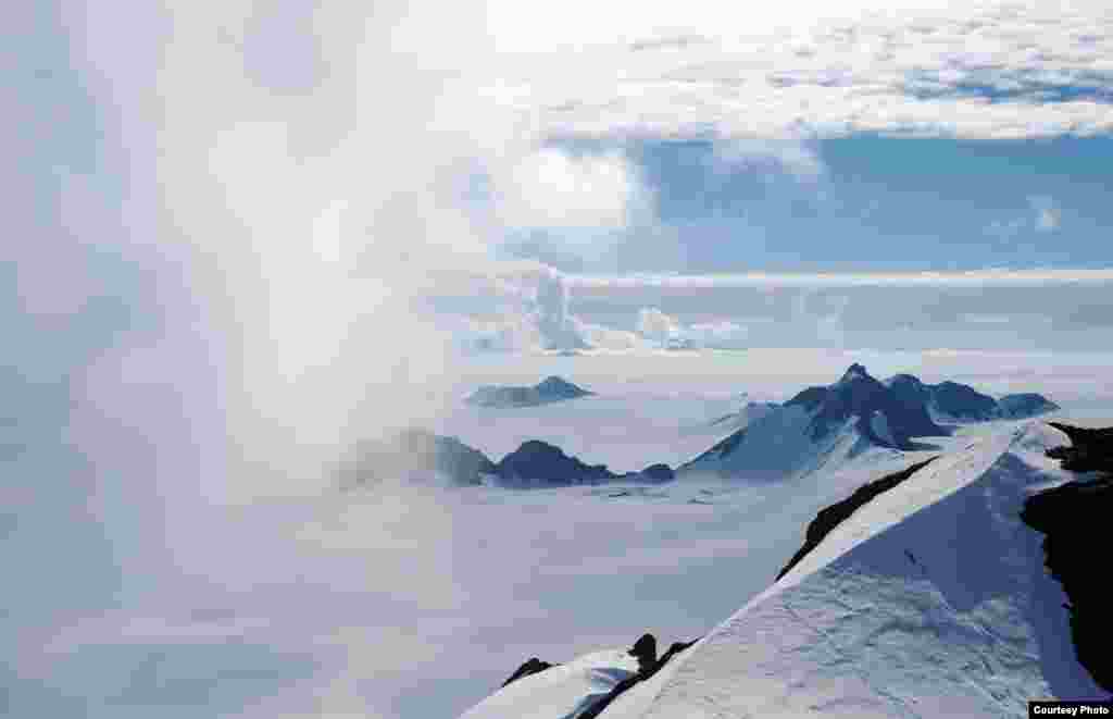 Awan musim panas berputar di puncak Staccato Pulau Alexander, Semenanjung Antartika. (Hamish Pritchard/British Antarctic Survey)