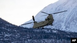 In this photo provided by the Alaska National Guard, a CH-47 Chinook helicopter departs Bryant Army Airfield, Dec. 11, 2020.