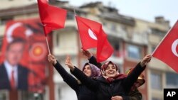 Supporters of Turkey's President Recep Tayyip Erdogan, waiting for his speech, wave Turkish flags, during a rally for the upcoming referendum, in his hometown city of Rize, in the Black Sea region of Turkey, April 3, 2017. 
