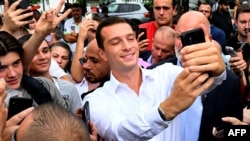 President of the French far-right party Rassemblement National (RN) and MEP Jordan Bardella takes a selfie as he arrives to attend the 78th edition of the Agricultural and Trade Fair in Chalons-en-Champagne, northern France, on September 7, 2024. (Phot