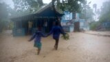 Residents wade through flood waters in Leogane, Haiti, Oct. 4, 2016