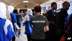 Members of the Afghan team, left, walk past two Burundi team members, at right in black shirts, during the FIRST Global Robotics Challenge in Washington, July 17, 2017. Six Burundians participants disappeared after the competition. 