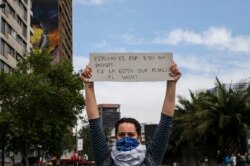 A demonstrator raises a sign that reads in Spanish "This is not for 30 pesos in fare, it's the drop that overflows the glass" during a protest in Santiago, Chile, Oct. 19, 2019.