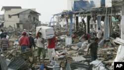 Para penyintas di tengah puing-puing akibat tsunami di Banda Aceh, 31 Desember 2004.