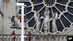 Firefighters work near the rose window of Notre Dame cathedral, Apr. 16, 2019 in Paris.