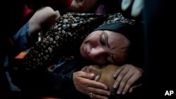 Una mujer palestina llora a su hijo, Mahmoud Essa, de 12 años, asesinado por el bombardeo israelí de la Franja de Gaza, en el Hospital de Al Aqsa en Deir al Balah, en la Franja de Gaza, la madrugada del domingo 12 de mayo de 2024.