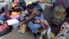  FILE - Migrants from Cameroon rest while waiting with other migrants from Africa and Haiti to request humanitarian visas, issued by the Mexican government, to cross the country towards the United States, in Tapachula, Mexico June 27, 2019. 