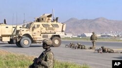 Soldados estadounidenses custodian lo largo de un perímetro en el aeropuerto internacional de Kabul, Afganistán, el lunes 16 de agosto de 2021.