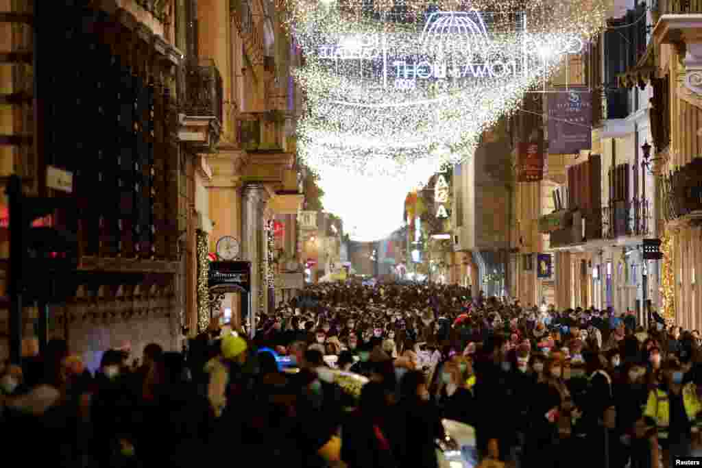 People walk along Via Del Corso street as the government prepares further restrictions over the Christmas period in an attempt to curb the spread of the COVID-19 in Rome, Italy, Dec. 19, 2020.