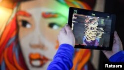 In this file photo, hands holding a tablet computer are pictured during a tour through the urban NFT LAB called "GAME OVER" by the artist group Die Dixons (aka XI DE SIGN) in Berlin, Germany, on October 6, 2021. (REUTERS/Annegret Hilse/File Photo)