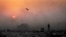 FILE- A thick blanket of smoke is seen against the setting sun as young ragpickers search for reusable material at a garbage dump in New Delhi, India, Oct. 17, 2014.